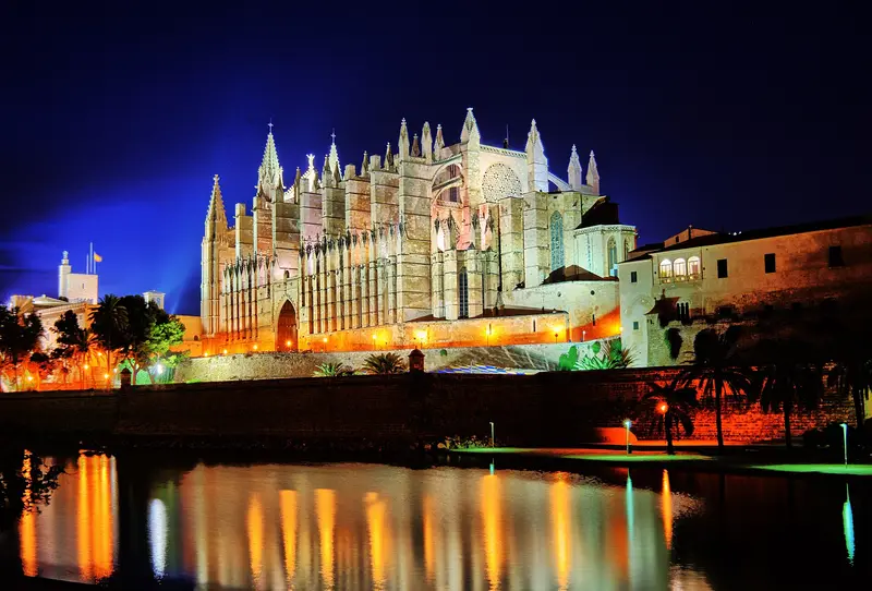 Catedral de Mallorca iluminada de noche sobre la bahía de Palma